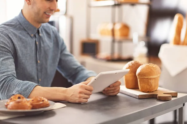 Hombre usando tableta en la panadería. Dueño de pequeña empresa — Foto de Stock