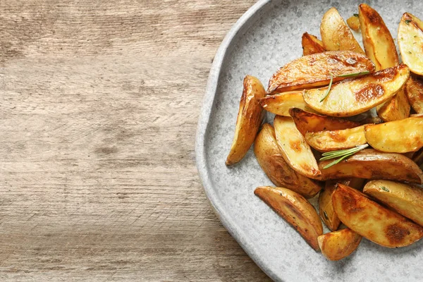 Prato com saborosas fatias de batata na mesa — Fotografia de Stock