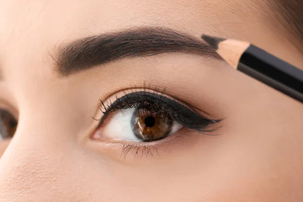 Mujer joven corrigiendo la forma de las cejas, primer plano —  Fotos de Stock