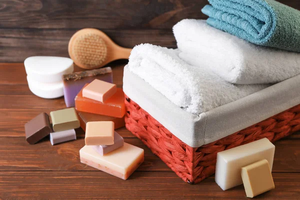 Soft towels and different soap bars on table — Stock Photo, Image