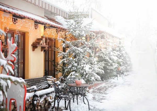 Hermosa vista de la calle de la ciudad con cafetería y abetos en invierno — Foto de Stock