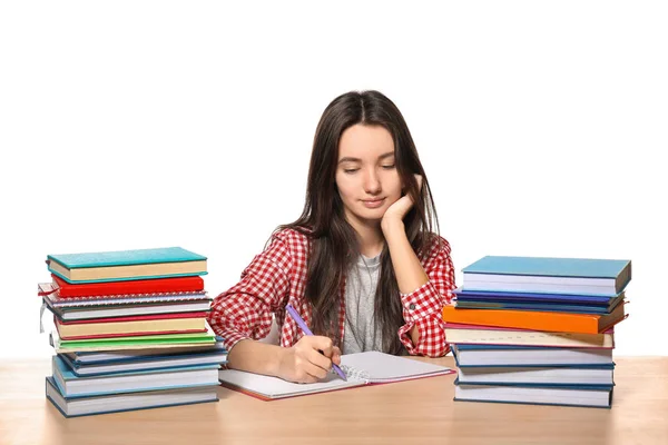 Carino adolescente ragazza facendo i compiti contro sfondo bianco — Foto Stock