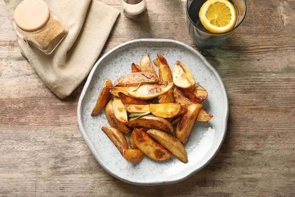 Prato com saborosas fatias de batata na mesa — Fotografia de Stock