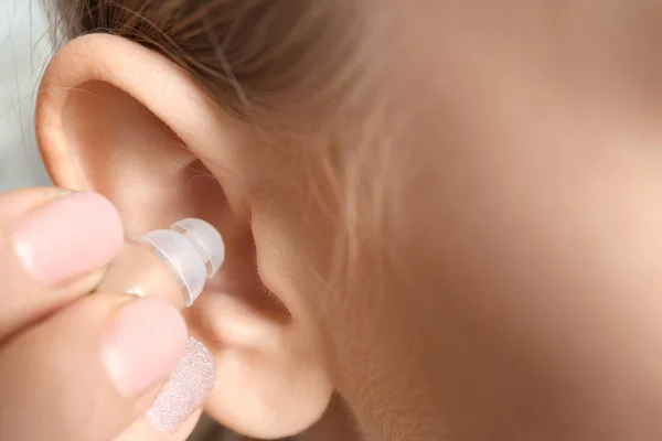 Νεαρή γυναίκα βάζοντας ακουστικό βαρηκοΐας στο αυτί, κοντινό πλάνο — Φωτογραφία Αρχείου