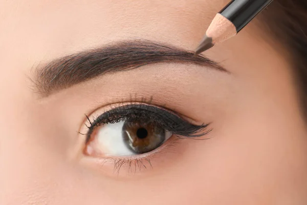 Mujer joven corrigiendo la forma de las cejas, primer plano —  Fotos de Stock