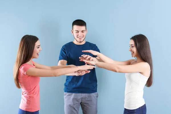 Ungdomar sätta händerna tillsammans på färgbakgrund. Unity-konceptet — Stockfoto