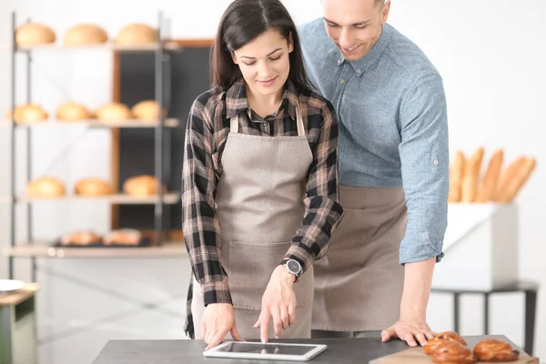 Jóvenes que usan tableta en panadería. Dueños de pequeñas empresas — Foto de Stock