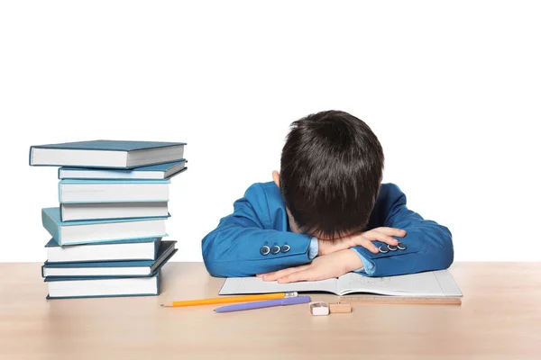 Sleeping little boy tired of doing homework against white background — Stock Photo, Image