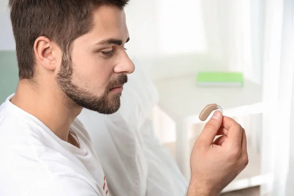 Joven con audífono en el interior —  Fotos de Stock