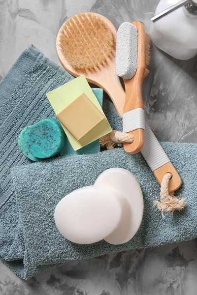 Toalla suave, diferentes barras de jabón y accesorios de baño en la mesa — Foto de Stock