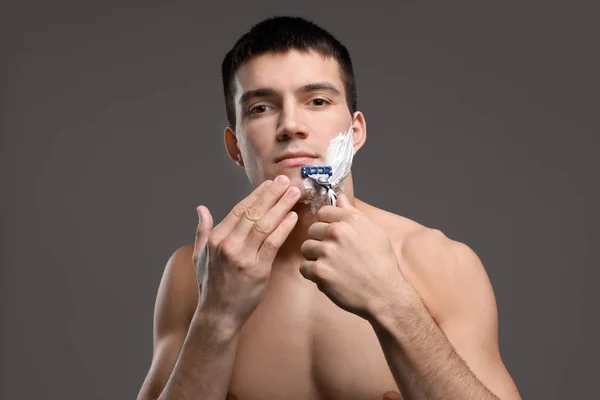 Красивый молодой человек бреется — стоковое фото