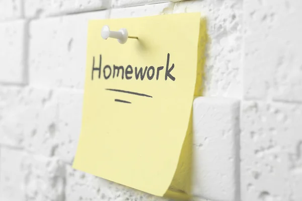 Зауваження зі словом "Домашнє завдання" прикріплене до стіни — стокове фото