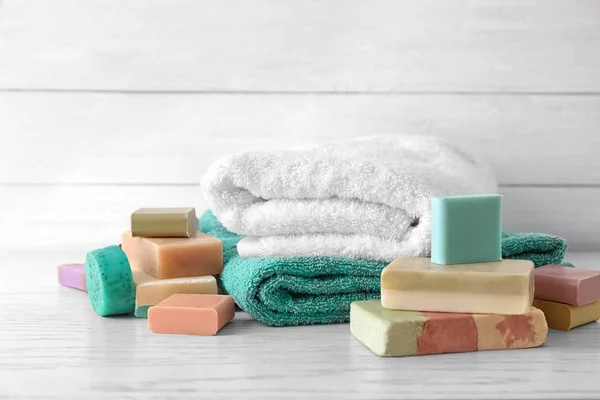 Mjuka handdukar och olika tvålar på bord — Stockfoto