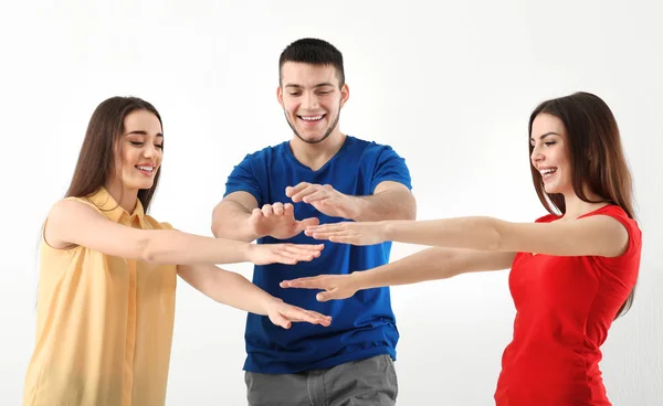 Mladí lidé uvedení ruce společně na světlém pozadí. Koncepce jednoty — Stock fotografie