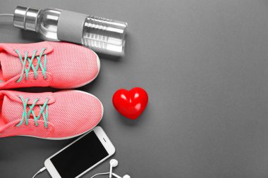 Spor salonu kalp gri arka plan üzerinde şeyler, telefon ve kırmızı. Kardiyo eğitim kavramı