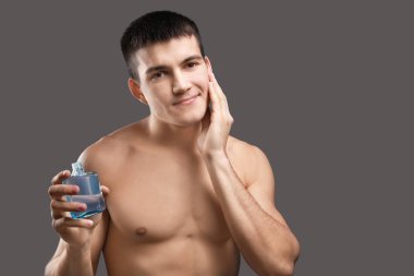 Tıraş losyonu gri arka plan uygulama yakışıklı genç