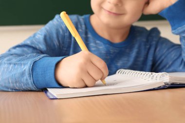 Küçük çocuk ödevini yapıyor.