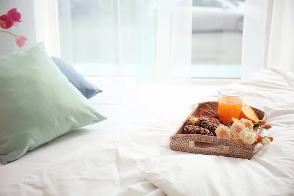 Трай с вкусным завтраком на удобной кровати дома — стоковое фото