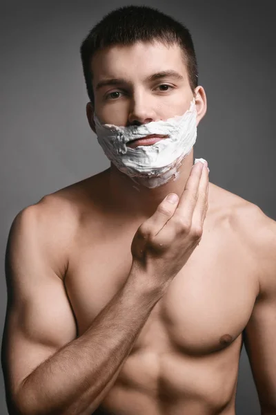 年轻男子剃须泡沫的应用 — 图库照片