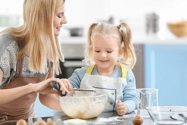 Mãe e filha preparando massa dentro de casa — Fotografia de Stock