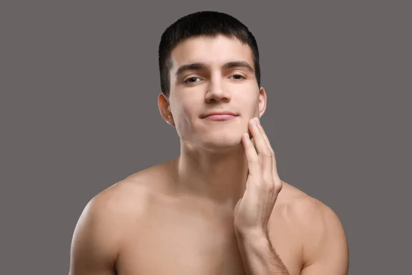 Handsome young man with soft skin after shaving against grey background — Stock Photo, Image