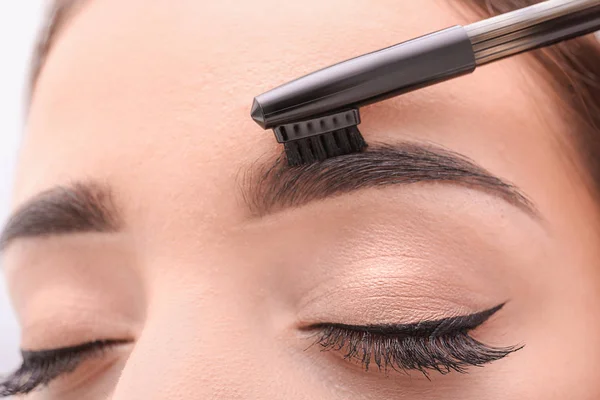 Woman correcting shape of eyebrows — Stock Photo, Image
