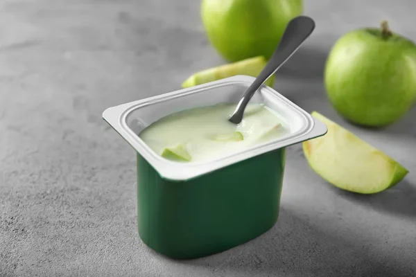 Tasse en plastique avec yaourt aux pommes délicieux sur la table — Photo