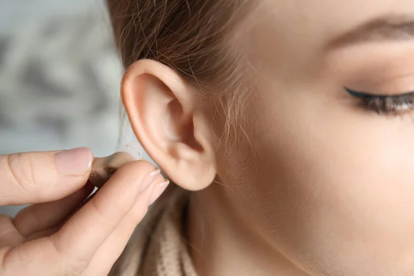 Arzt steckt Frau Hörgerät ins Ohr, Nahaufnahme — Stockfoto