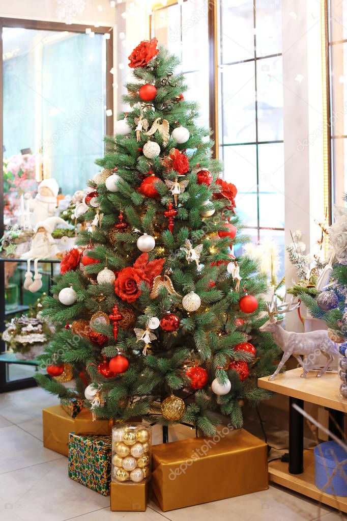 Beautiful Christmas tree decorated by professional florist in flower shop