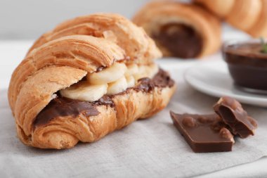 Tablo üzerinde muz ve çikolata soslu lezzetli kruvasan