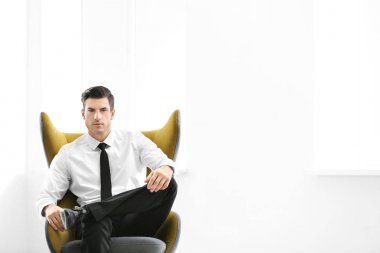 Yakışıklı işadamı kapalı rahat koltukta oturan