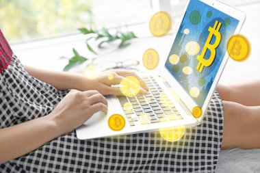 Bitcoin simgeler ve dizüstü evde kullanan kadın