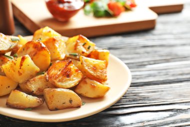 Plaka üzerinde ahşap masa lezzetli patates dilimleri ile