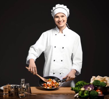 Tek tip koyu arka planı pişirme kadın Şef