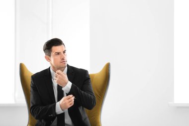 Yakışıklı işadamı kapalı rahat koltukta oturan