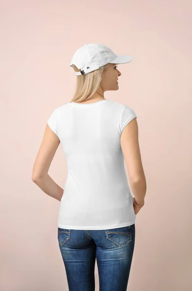 スタイリッシュな シャツとキャップ色の背景上で若い女性 デザインのモックアップ — ストック写真