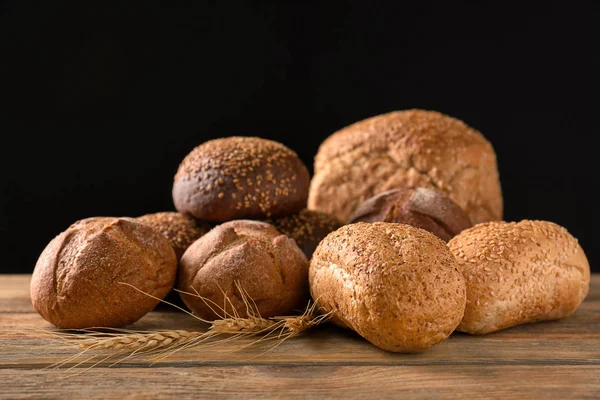 Berbagai Roti Segar Yang Lezat Atas Meja Kayu Dengan Latar — Stok Foto