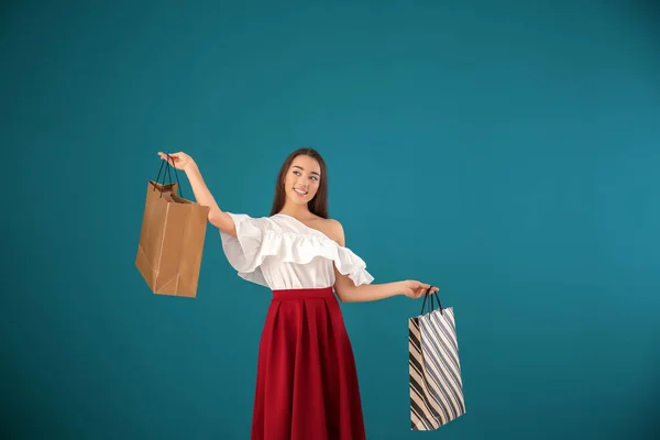 Schöne Junge Frau Mit Einkaufstaschen Auf Farbigem Hintergrund — Stockfoto