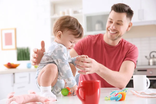 Отец играет со своим маленьким сыном на кухне — стоковое фото