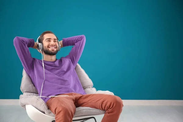Handsome Man Listening Music While Sitting Comfortable Armchair Color Wall — Stock Photo, Image