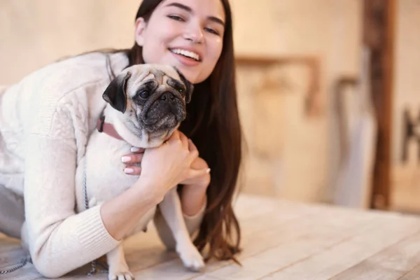 Mujer joven con gato lindo sentado en la mesa en la cocina — Foto de Stock