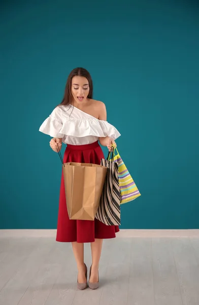 Schöne Junge Frau Mit Einkaufstaschen Gegen Farbwand — Stockfoto