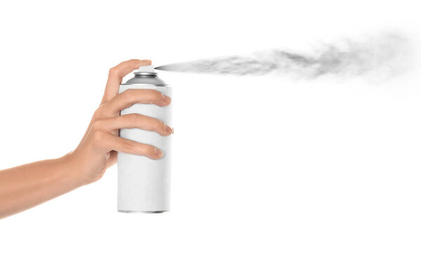 Woman spraying paint from can on white background