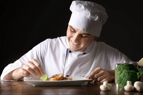 Chef Maschio Uniforme Guarnire Gustoso Piatto Contro Sfondo Nero — Foto Stock