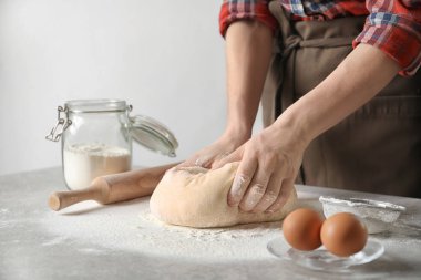 Kadın masada hamur yoğurma un serpilir