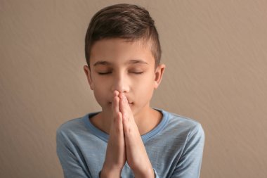 Küçük çocuk koyu arka plan üzerinde dua