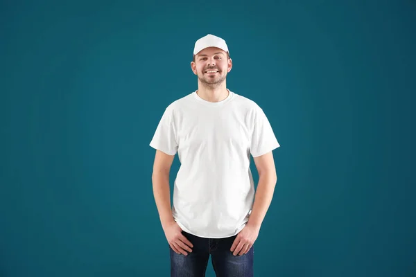 年轻男子穿着时髦的 T恤衫和帽子的颜色背景 设计样机 — 图库照片