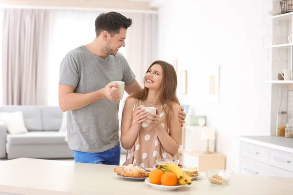 キッチンで朝食をとる若いカップルは — ストック写真