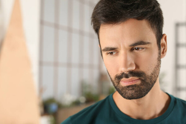 Young bearded man in casual clothes indoors