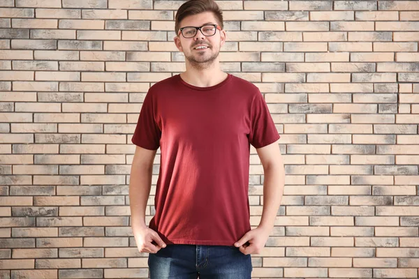 レンガ壁の背景にスタイリッシュな シャツの若い男 デザインのモックアップ — ストック写真